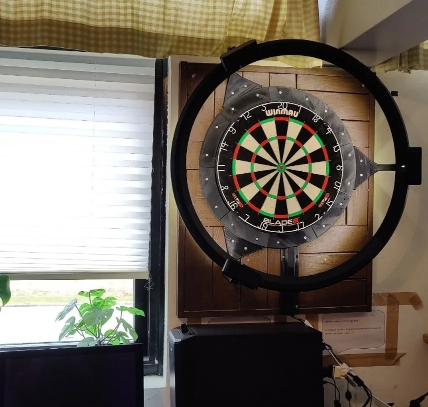 The dart scoring rig mounted around a dartboard on the wall